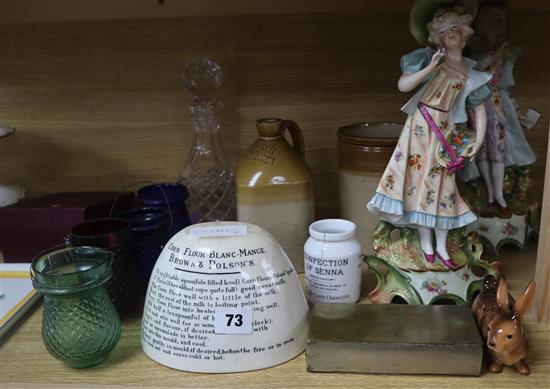 An advertising stoneware jug, a pair of porcelain figures, a jelly mould etc